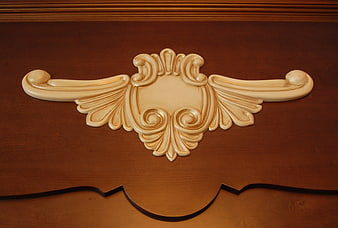 Ornate Cream Rococo Wood Carving on Brown Furniture