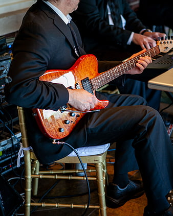 Musician playing electric guitar in black suit