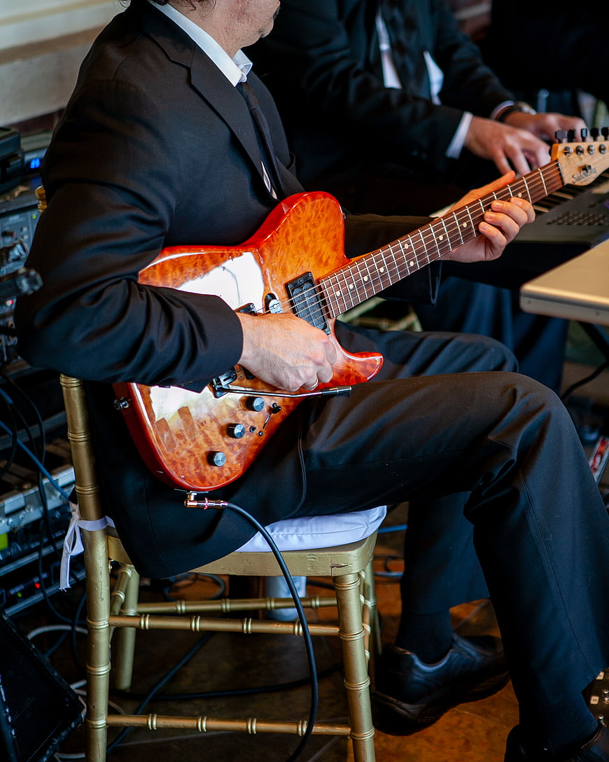 Musician playing electric guitar in black suit