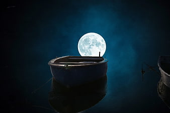 Silhouette of a boat with a full moon rising behind it