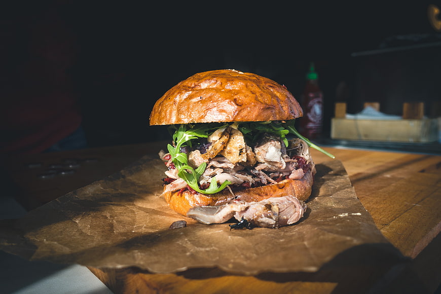 Gourmet confited duck burger on rustic wooden table