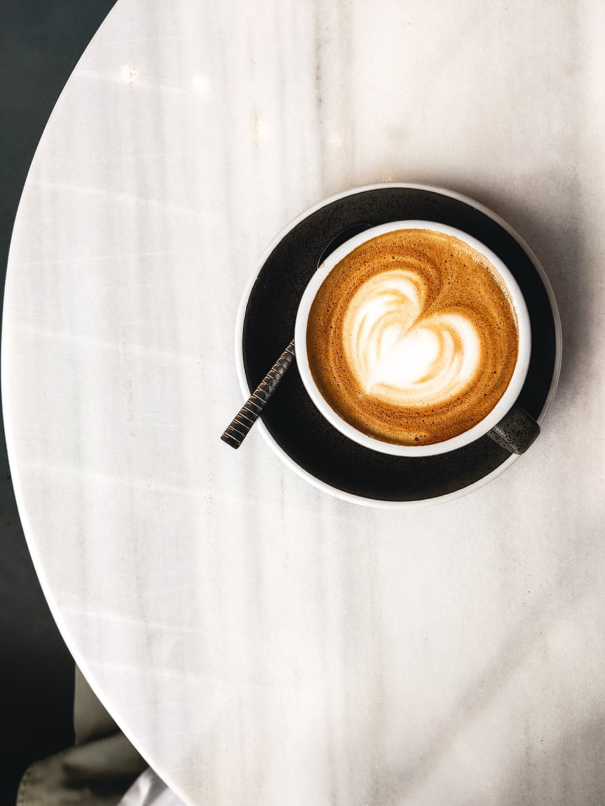 Top view of cappuccino with heart latte art on marble table