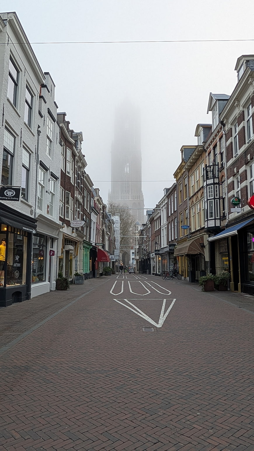 Foggy Dutch Street with Church Tower in the Distance