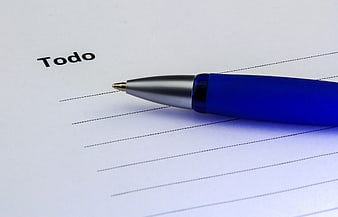 Blue ballpoint pen on a to-do list notepad