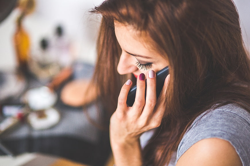 Close-up of woman talking on smartphone with painted nails