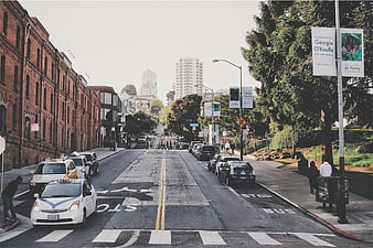 Urban street scene with taxis, crosswalk, and brick buildings
