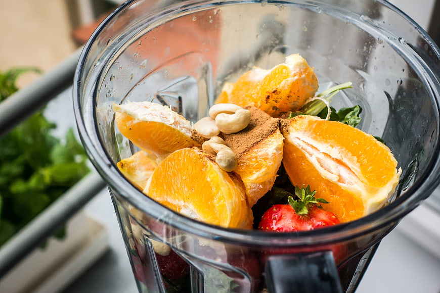 Fresh orange and strawberry smoothie ingredients in blender
