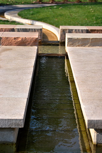 Modern stone water feature with flowing stream in park