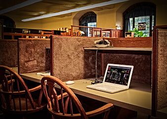 White laptop on desk in quiet library study carrel