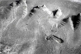 Black and white footprint in textured sand on a beach