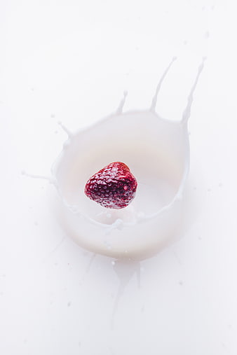 Fresh Strawberry Dropping into Milk Splash