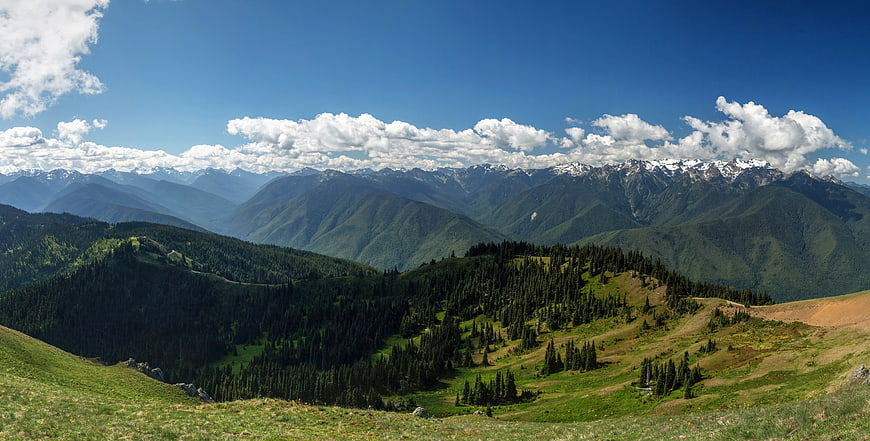 Panoramic Alpine Mountain Landscape with Green Hills and Blue Sky