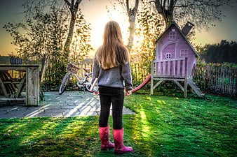 Little Girl in Pink Boots Standing in Garden at Sunset