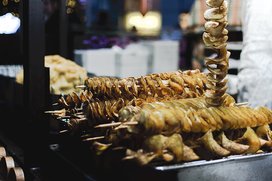 Fried potato chips twists on skewers at market