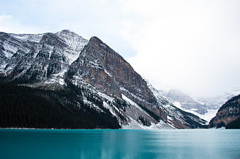 Turquoise Mountain Lake with Snowy Peaks and Forest