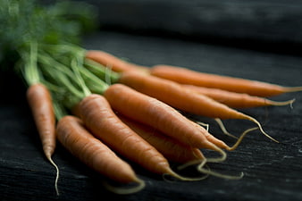 Fresh organic carrots on dark rustic wooden background