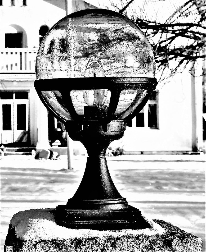Black and white close-up of a frosted outdoor lamp post in winter