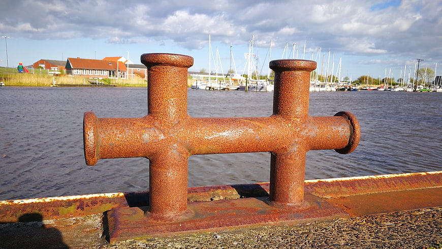 Rusty Harbor Bollard with Sailboats in Background