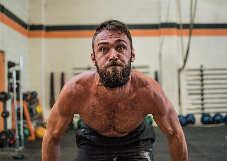 Intense Bearded Athlete Performing Push-Up In Gym
