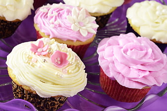 Decorated pink and white cupcakes on purple glass stand
