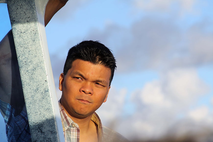 Portrait of man looking through metal structure against sky