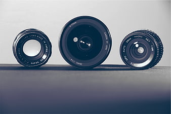 Three Vintage Camera Lenses on Dark Surface