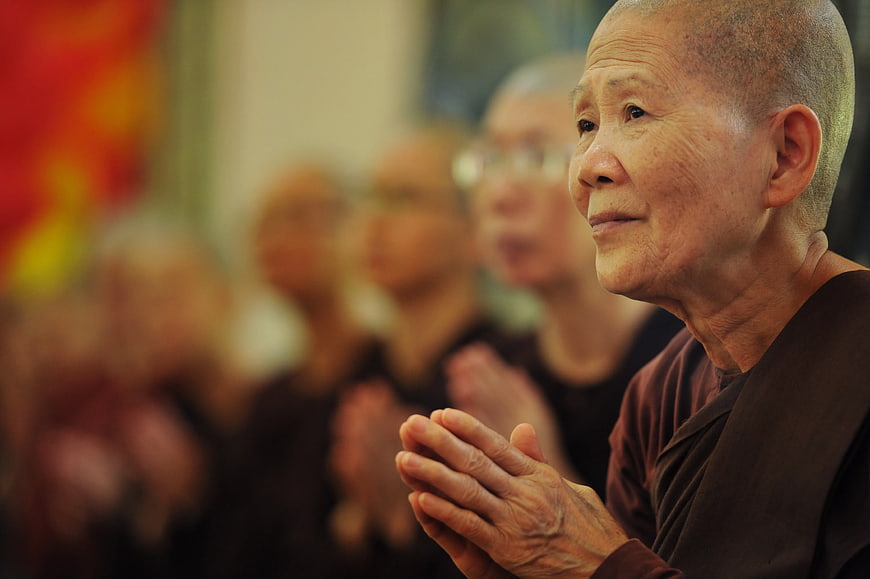 Senior Buddhist Nun Praying in Temple