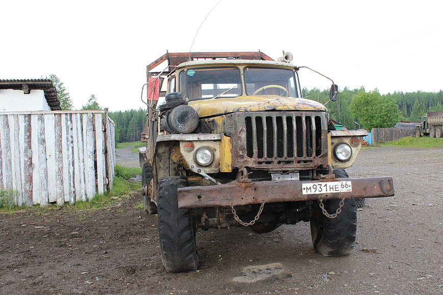 Rusty vintage Soviet military truck parked on dirt