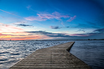Wooden Pier Extending into Lake at Colorful Sunset