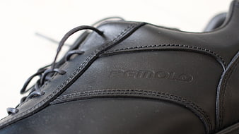 Close-up of black leather shoe with embossed logo