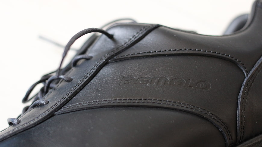 Close-up of black leather shoe with embossed logo