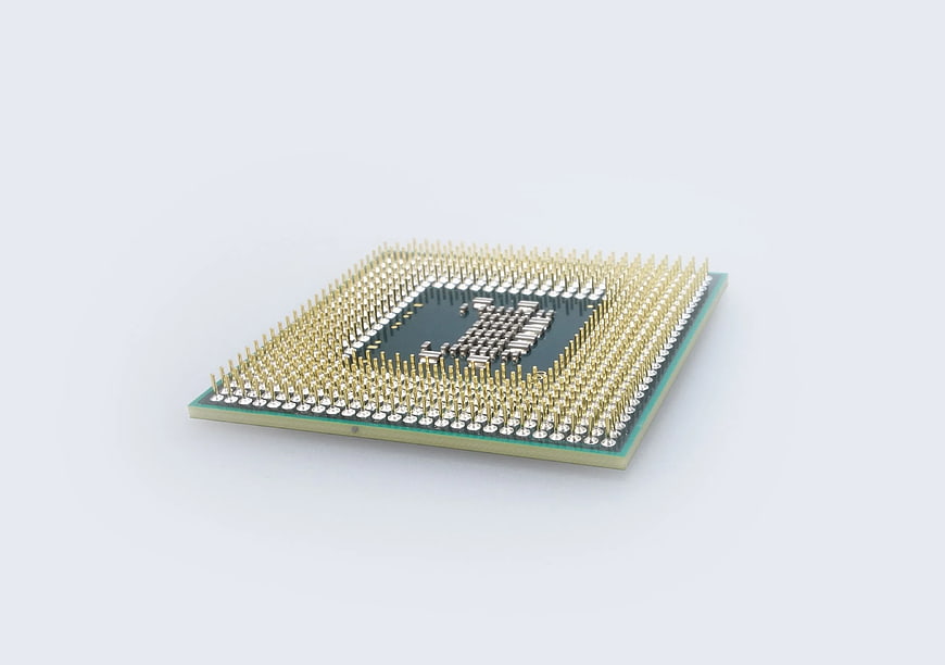 Close-up of CPU processor with gold pins on white background