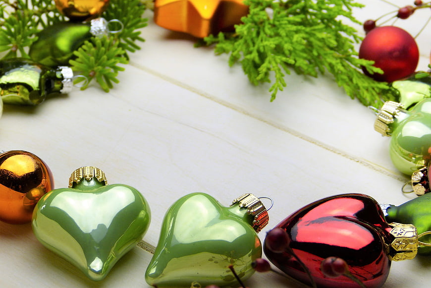 Christmas ornaments and fir branches on white wood background