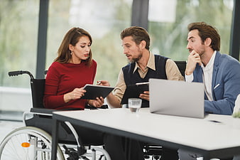Diverse business team meeting with woman in wheelchair