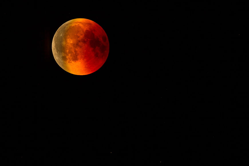 Partial Lunar Eclipse Blood Moon Against Black Night Sky