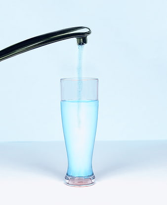 Clean water pouring from a modern chrome faucet into a clear glass
