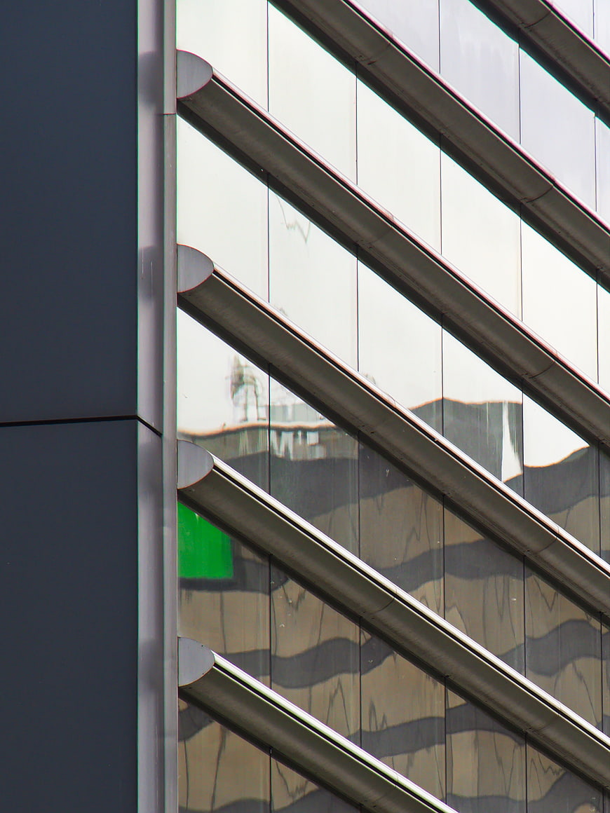 Modern Glass Building Facade with Diagonal Metal Louvers