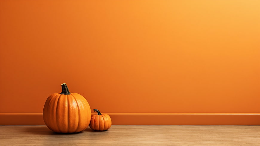 Two pumpkins on wooden floor with orange background