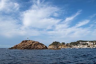 Rocky Island with Flag and Coastal Town in Tossa de Mar, Spain