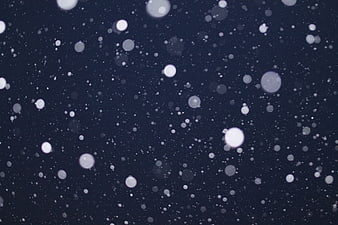 Falling Snowflakes Bokeh on Dark Blue Night Background