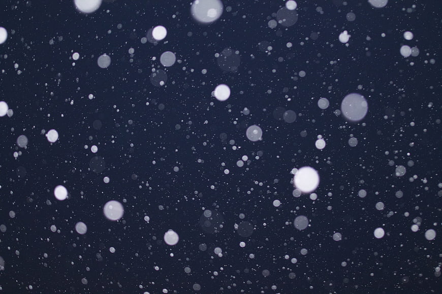 Falling Snowflakes Bokeh on Dark Blue Night Background