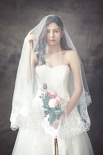 Elegant Bride in White Wedding Dress with Veil and Rose Bouquet