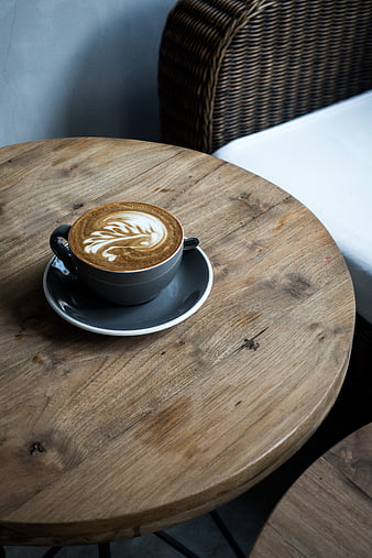 Cappuccino with latte art on rustic wooden table