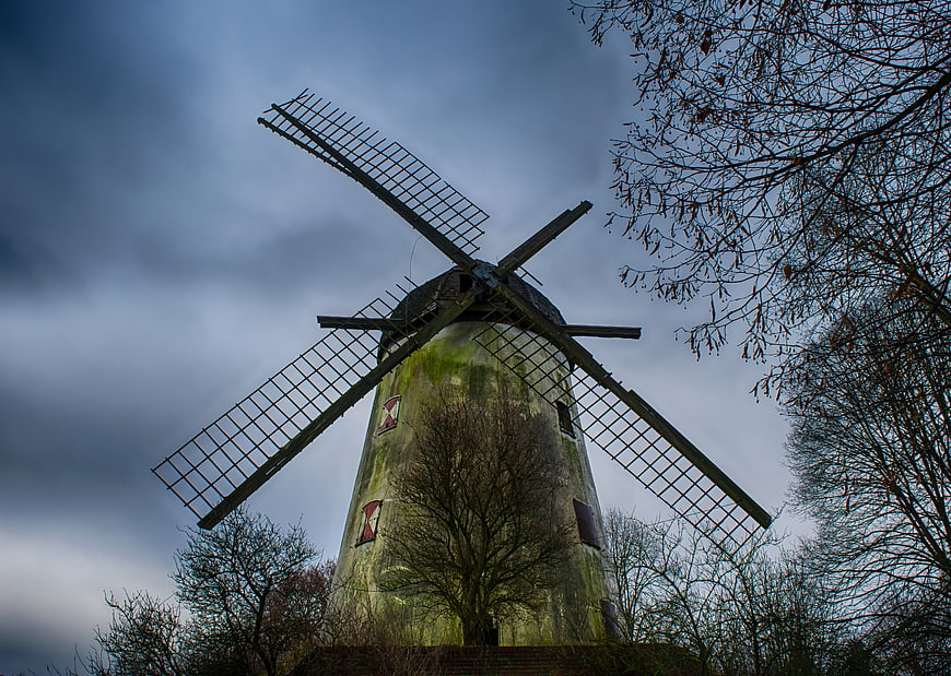 Dramatic Low Angle View of Old Weathered Windmill Under Stormy Sky