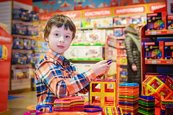 Young boy playing with magnetic building blocks in toy store