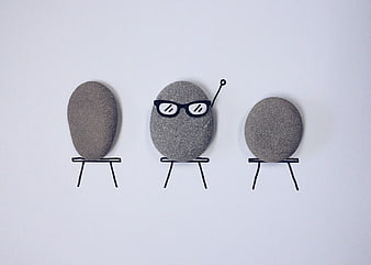 Creative stones with drawn glasses and chairs on white background