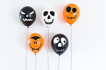 Halloween balloons with spooky faces on white background