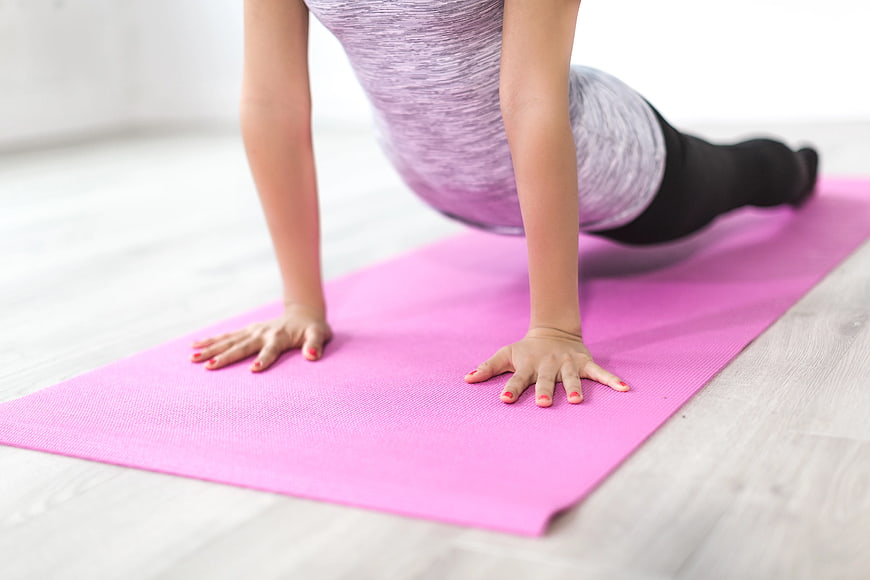 Woman doing yoga plank on pink mat