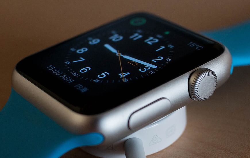 Silver Apple Watch with Blue Band on Charging Dock