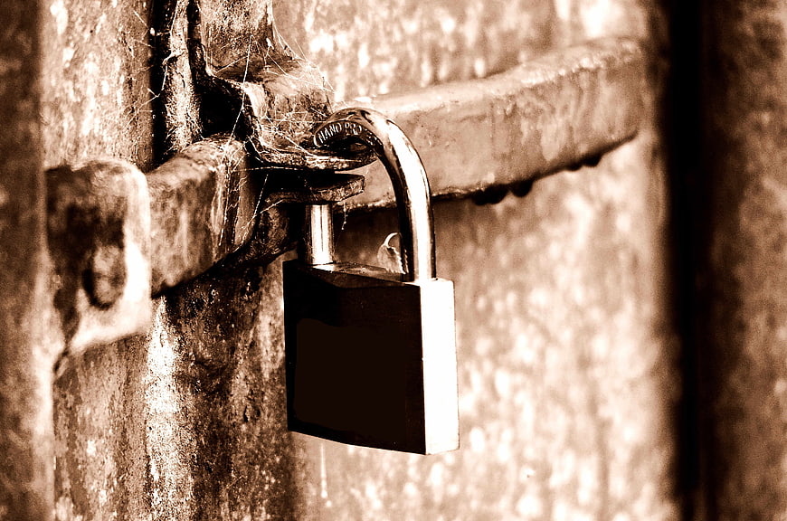 Vintage Padlock on Rusty Metal Door with Cobwebs
